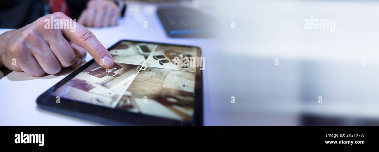 Businessman Looking At CCTV Camera Footage On Digital Tablet Stock Photo