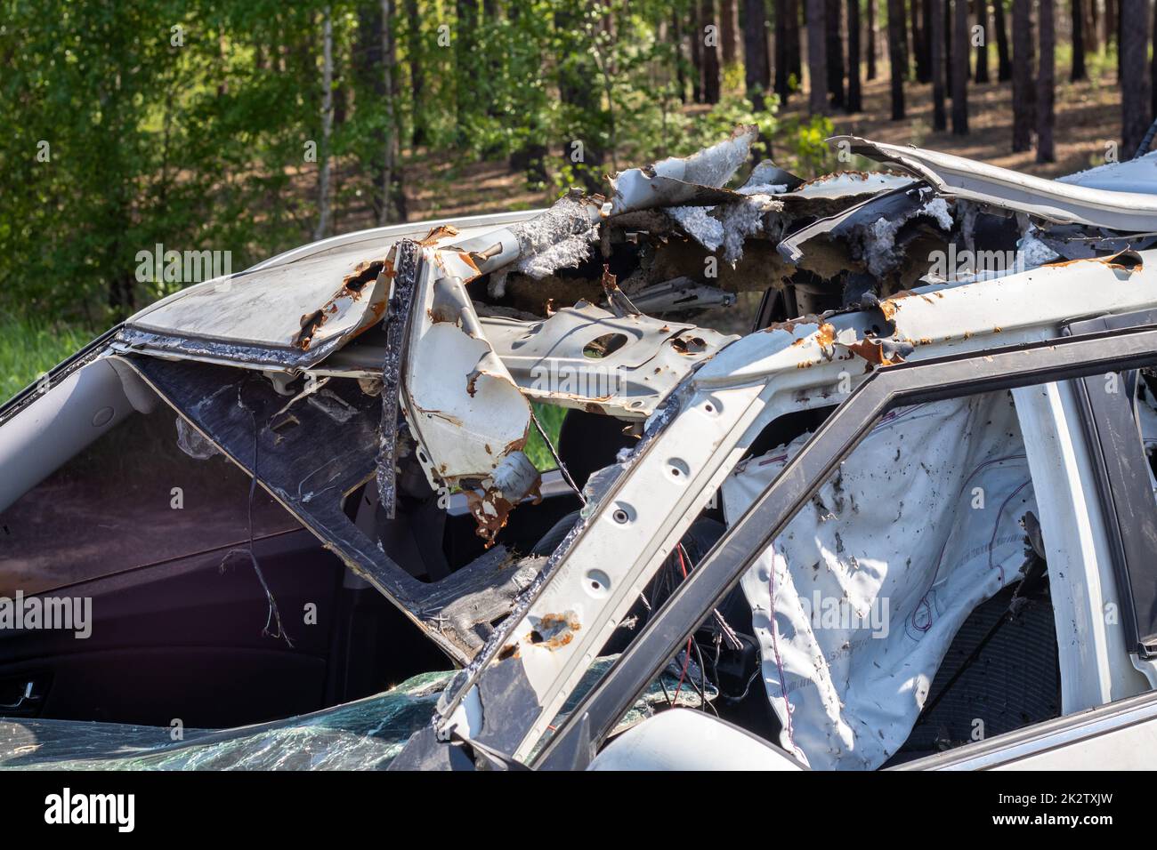The remains of a civilian car, which was shot and destroyed by shell fragments. The actions of the Russian army during the evacuation of women and children during the Russian invasion of Ukraine. Stock Photo