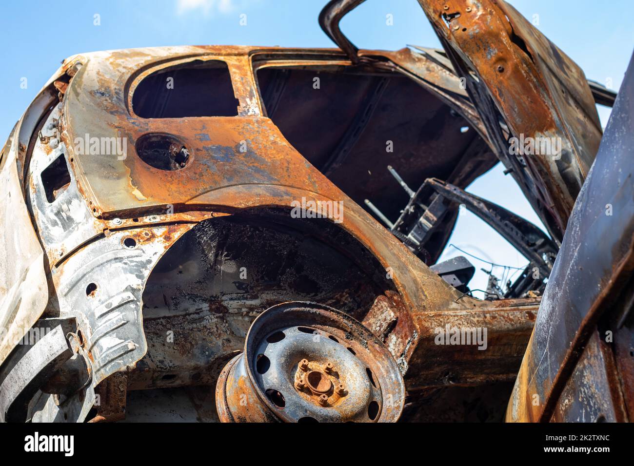 The car was completely destroyed by fire. Abandoned, burnt and rusty
