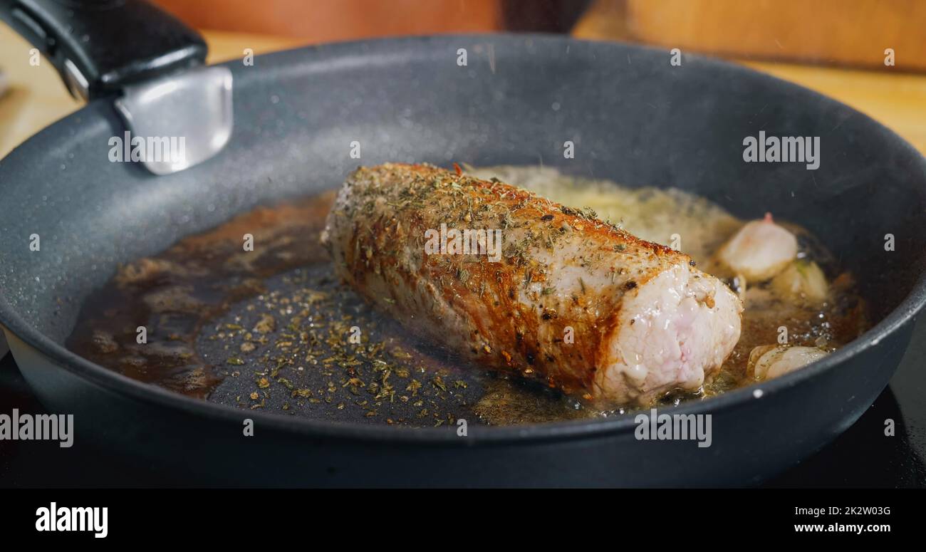 Seasoning with Falling Herbs on Fresh Fried Pork Meat. Professional