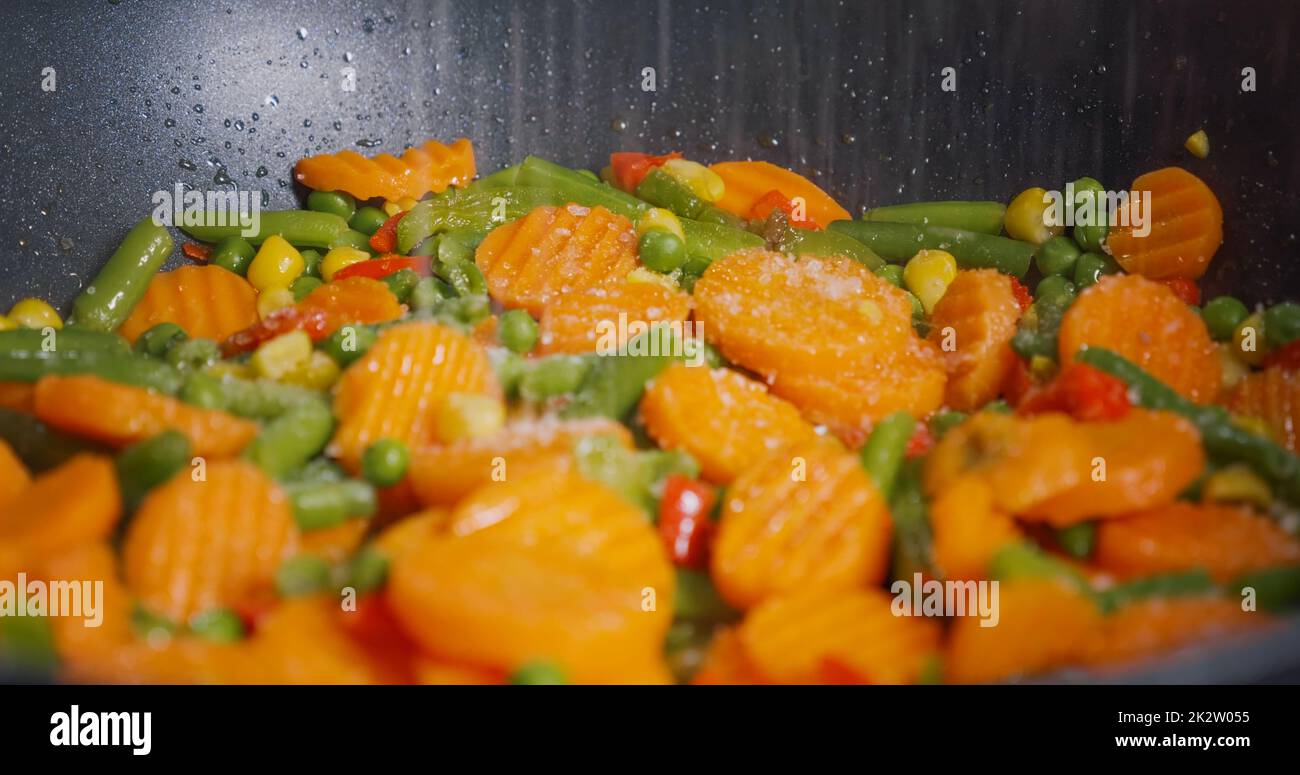 Season the vegetables cooked in a pan with salt Stock Photo Alamy