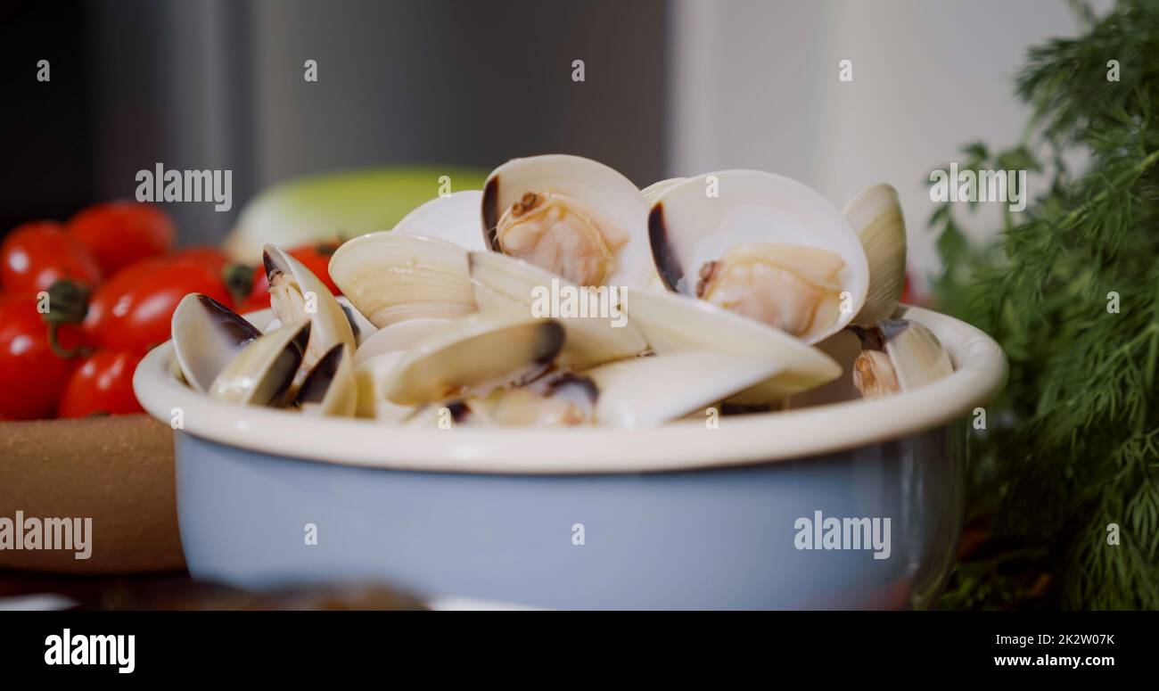 Bowl with fresh mussels, process of mediterranean dish preparation at home. Fresh Mollusks Cooking Seafood. Stock Photo