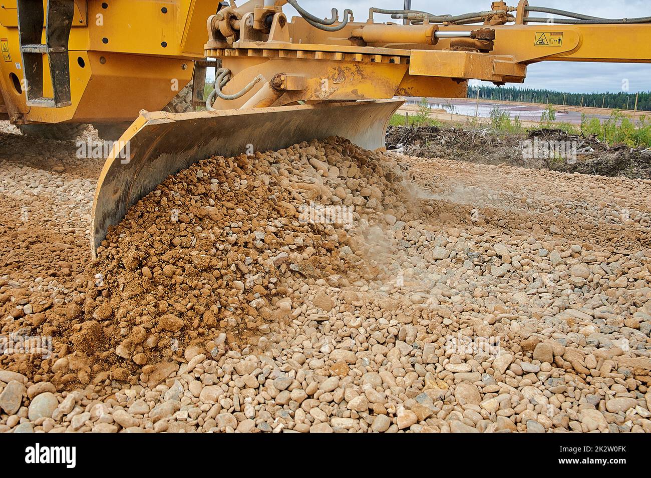 the grader blade levels the rubble at the construction site Stock Photo