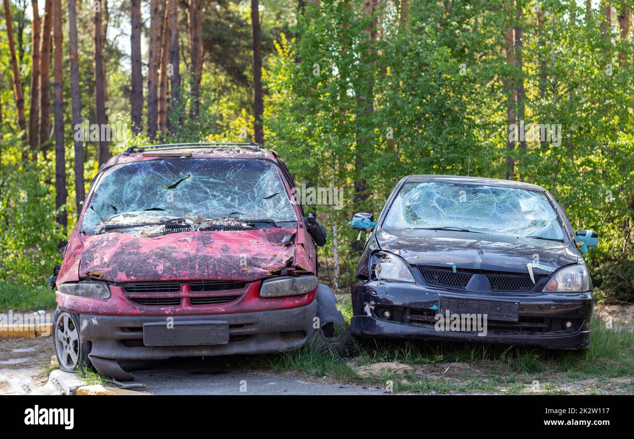 Many broken cars after a traffic accident in the parking lot of a restoration service station on the street. Car body damage workshop outdoors. Sale of insurance emergency vehicles at auction. Stock Photo