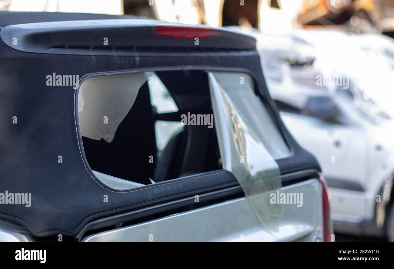 Damaged roof material on the back of the convertible. Vandalism, thieves cut the roof of a convertible from behind. Theft of things from the car. Criminal incident. Car burglary. Stock Photo