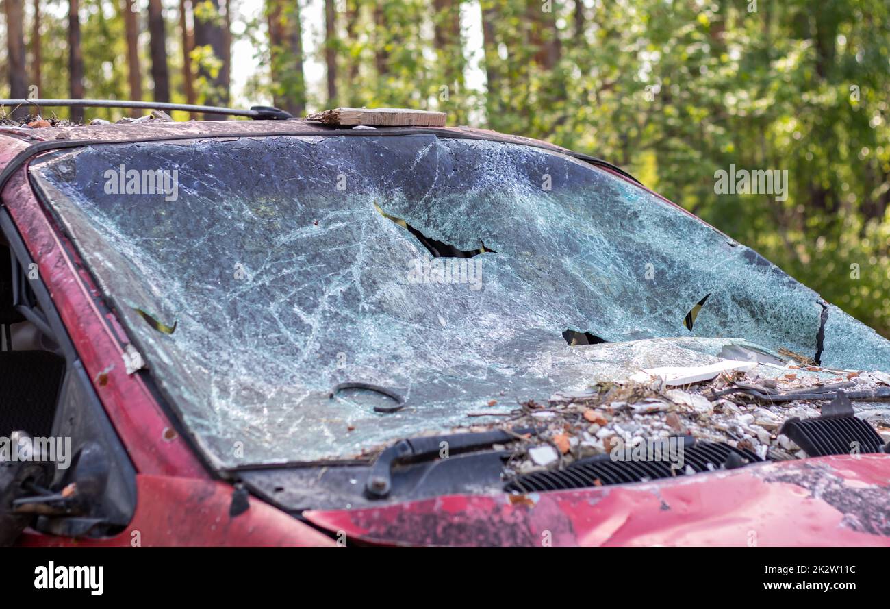 Close-up of a car with a broken windshield after a fatal crash. Consequence of a fatal car accident. Automobile danger. Reckless dangerous driving. Vehicle after an accident with a pedestrian. Stock Photo