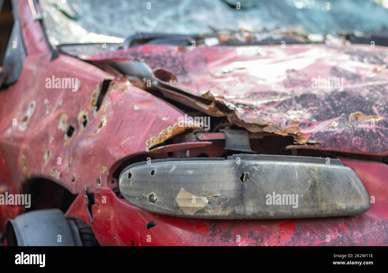 Car riddled with bullets. War of Russia against Ukraine. A car of civilians shot by the Russian military during the evacuation of women and children. Traces of bullets and fragments of shells. Stock Photo