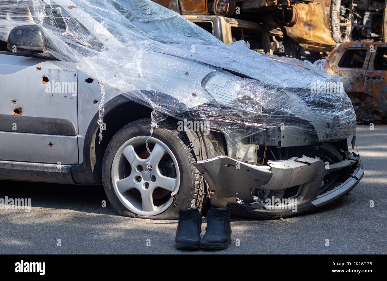 Shot, damaged cars during the war in Ukraine. The vehicle of civilians affected by the hands of the Russian military. Shrapnel and bullet holes in the body of the car. War of Russia against Ukraine. Stock Photo