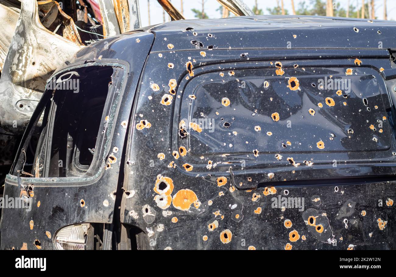 Shot, damaged cars during the war in Ukraine. The vehicle of civilians affected by the hands of the Russian military. Shrapnel and bullet holes in the body of the car. War of Russia against Ukraine. Stock Photo