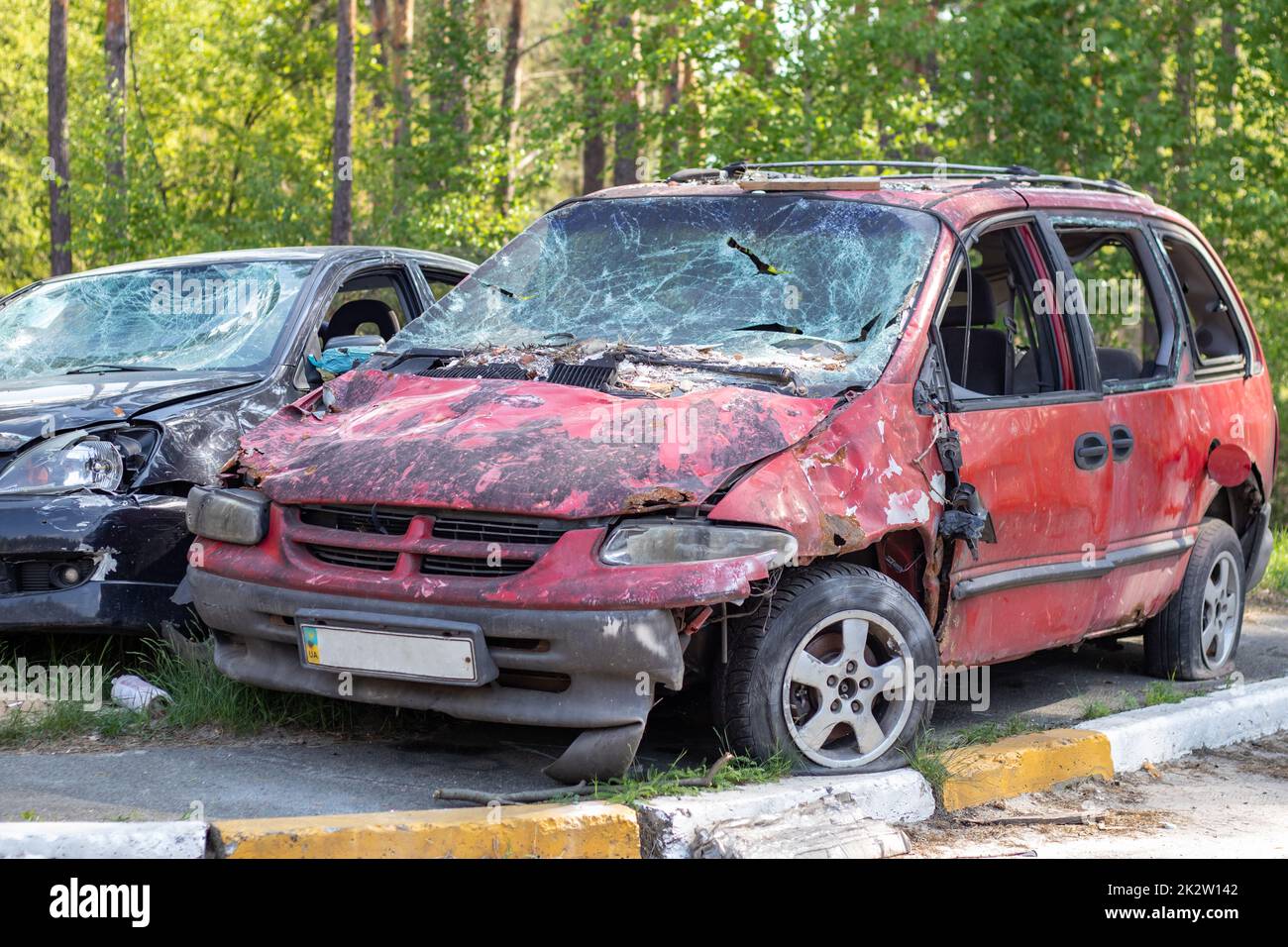 Shot, damaged cars during the war in Ukraine. The vehicle of civilians affected by the hands of the Russian military. Shrapnel and bullet holes in the body of the car. War of Russia against Ukraine. Stock Photo