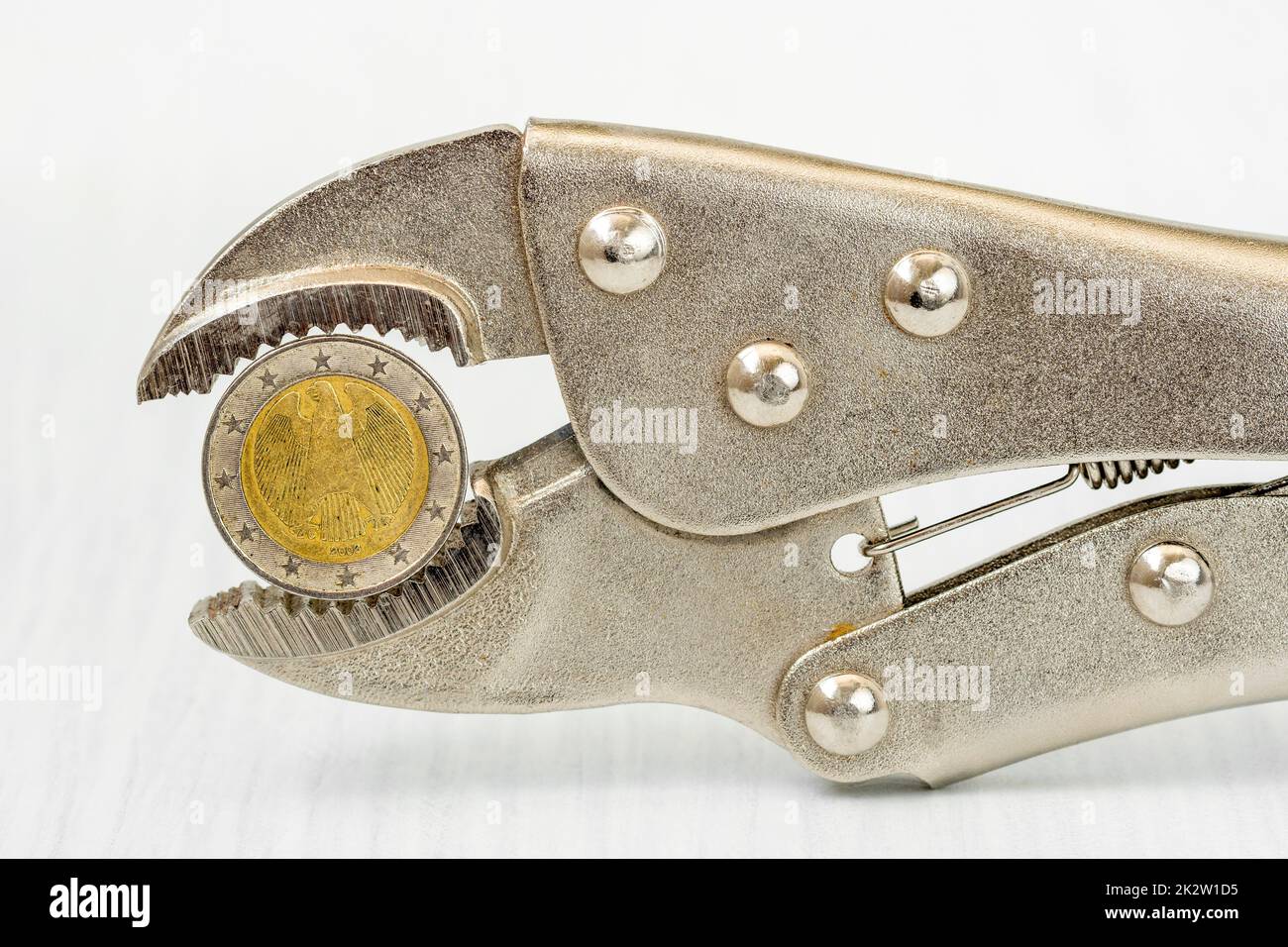 German Euro coin squeezed in an adjustable wrench Stock Photo Alamy