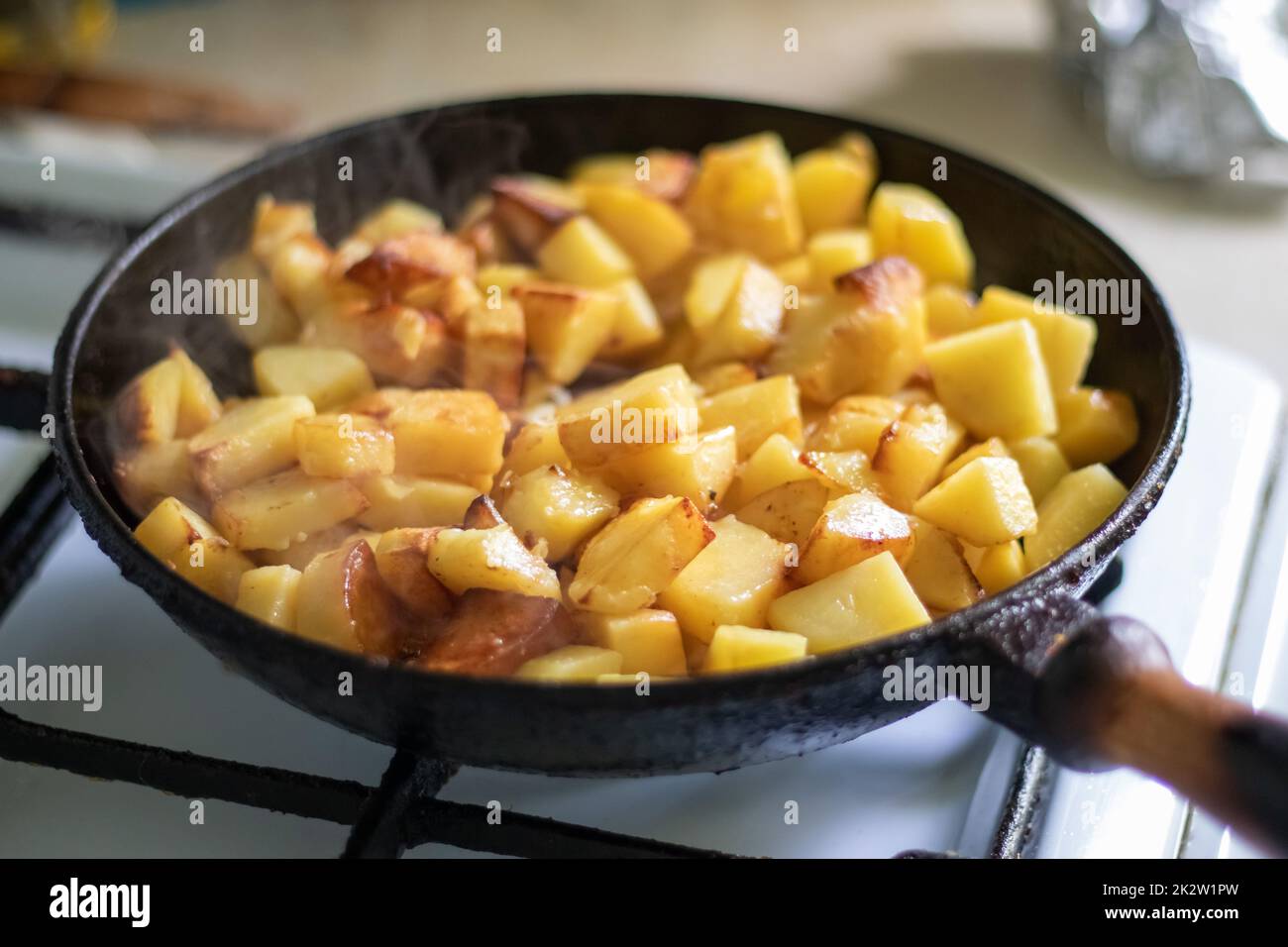 Roasting fresh potatoes in a cast iron skillet with sunflower oil. A