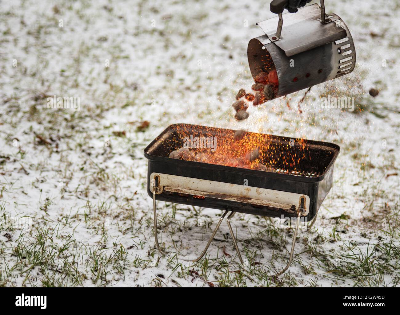 The grillman lights up the grill with a starter. The process of