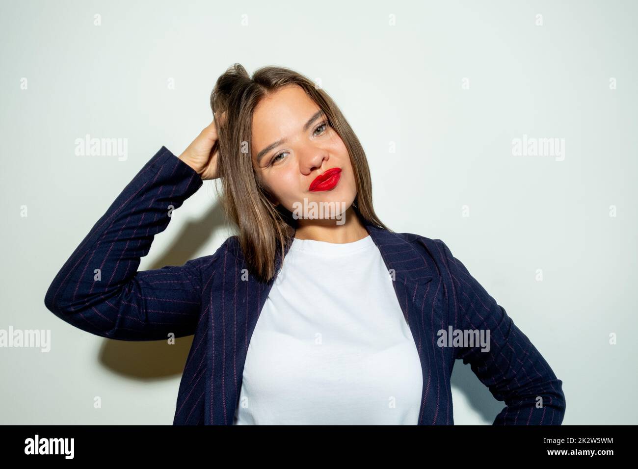 Doubtful business woman. Hard choice. Problem solution. Tough decision. Portrait of confused lady touching head looking at camera isolated on light ne Stock Photo