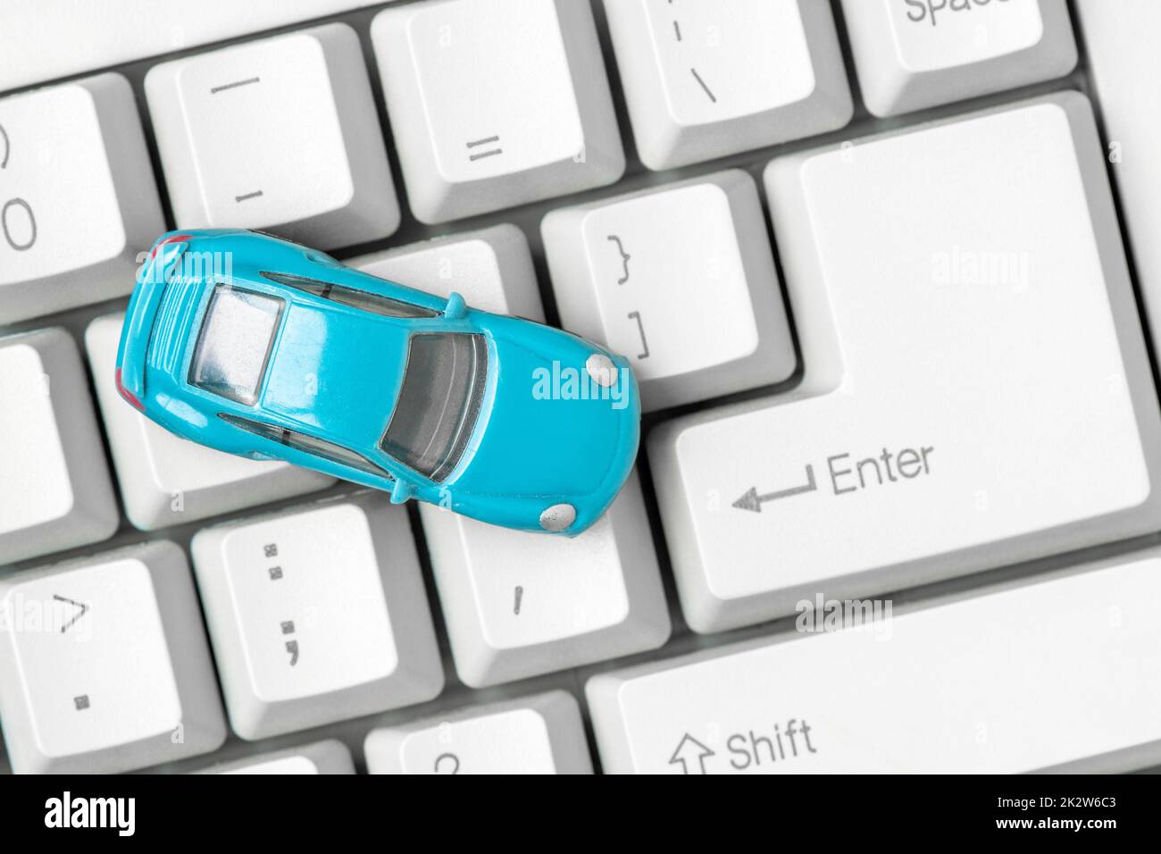 Small blue car on the computer keyboard Stock Photo