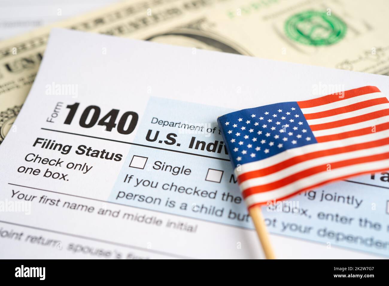 Tax Return form 1040 with USA America flag and dollar banknote, U.S