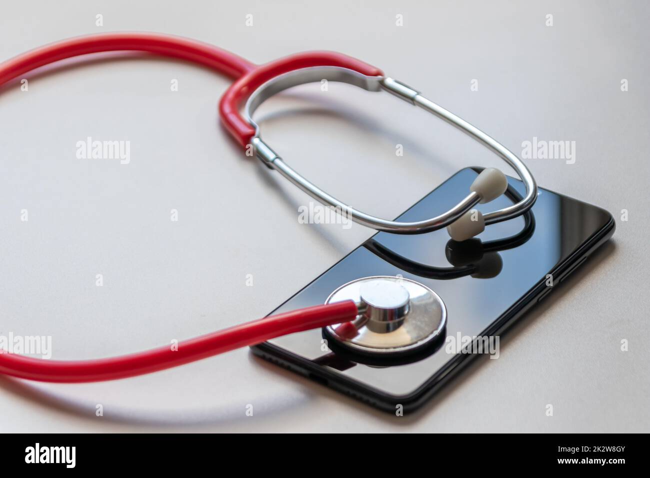 Red Stethoscope On Black Smartphone Represents Health Records And