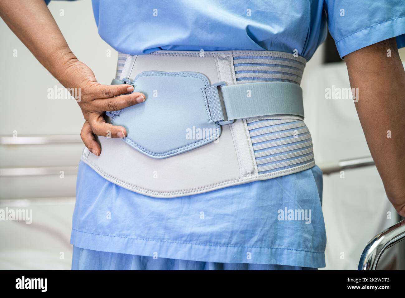 Asian lady patient wearing back pain support belt for orthopedic lumbar ...