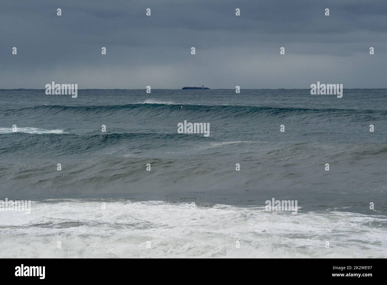 A scenic shot of a surfer catching a large wave at South Maroubra, Australia Stock Photo