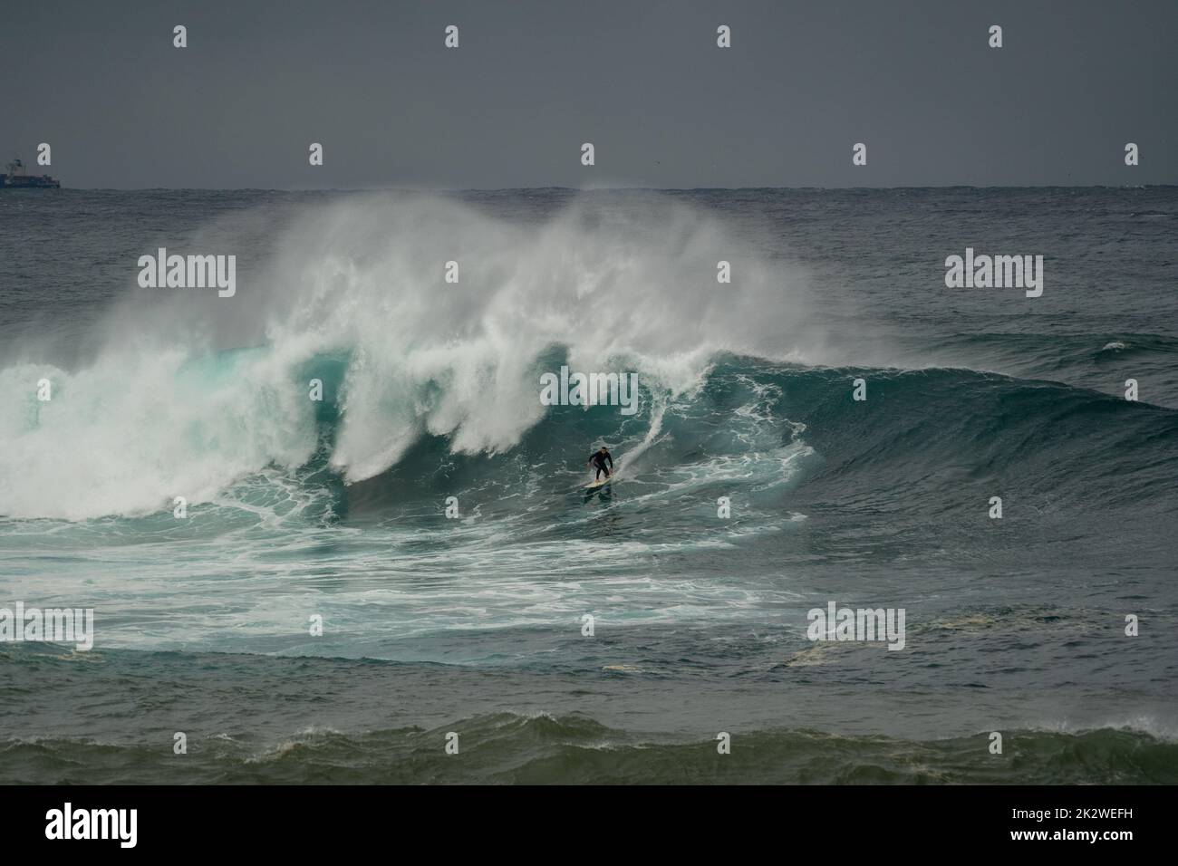 A closeup shot of a surfer surfing on a large wave at Wedding Cake Island, Sydney Stock Photo