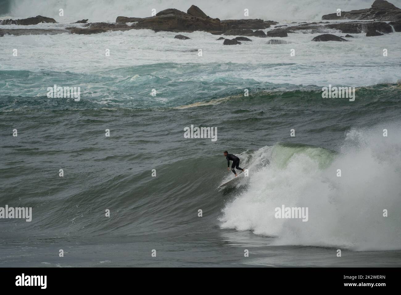 A closeup shot of a surfer surfing on a large wave at Wedding Cake Island, Sydney Stock Photo