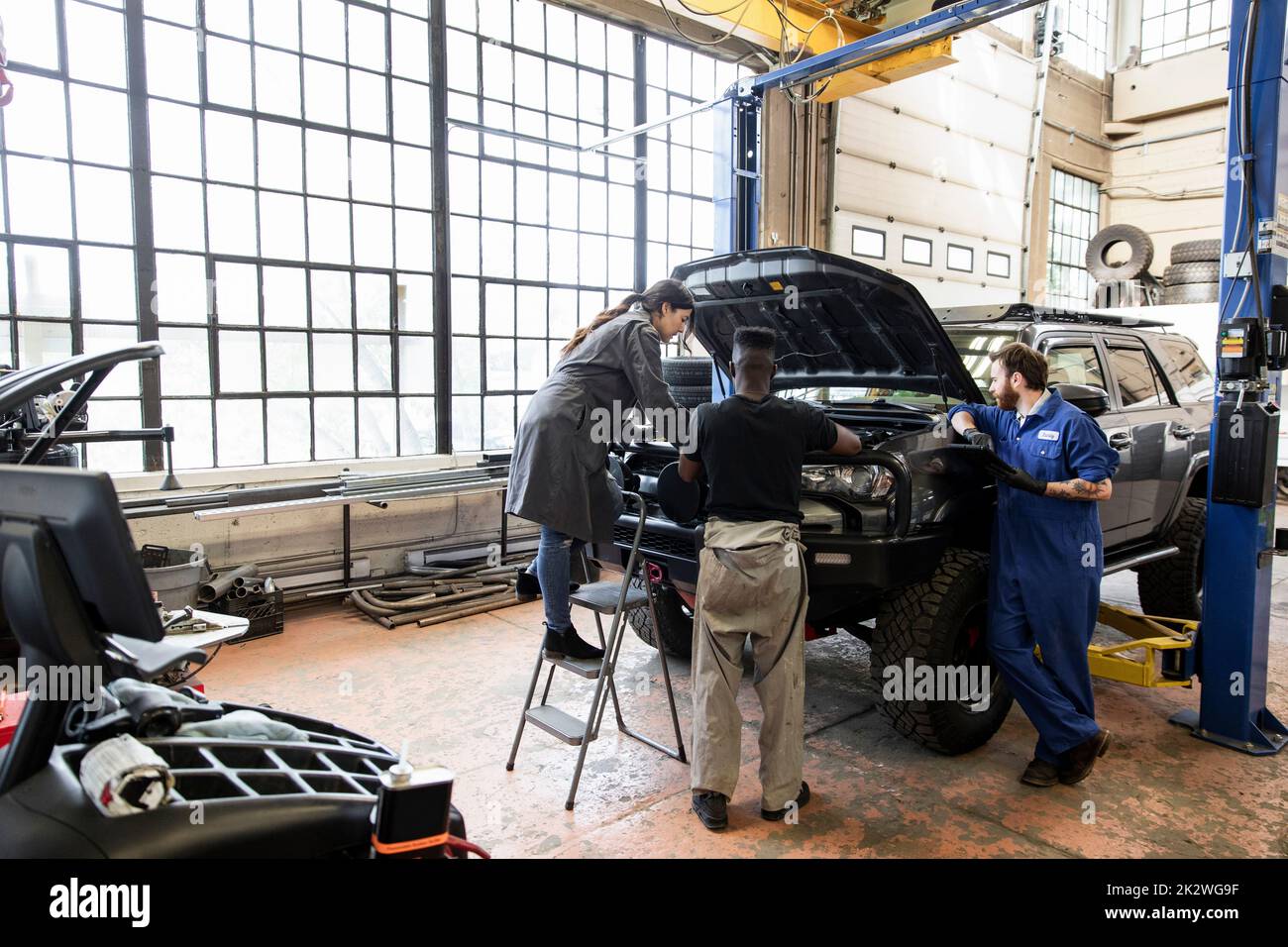 Auto mechanics customizing lifted SUV in garage Stock Photo Alamy
