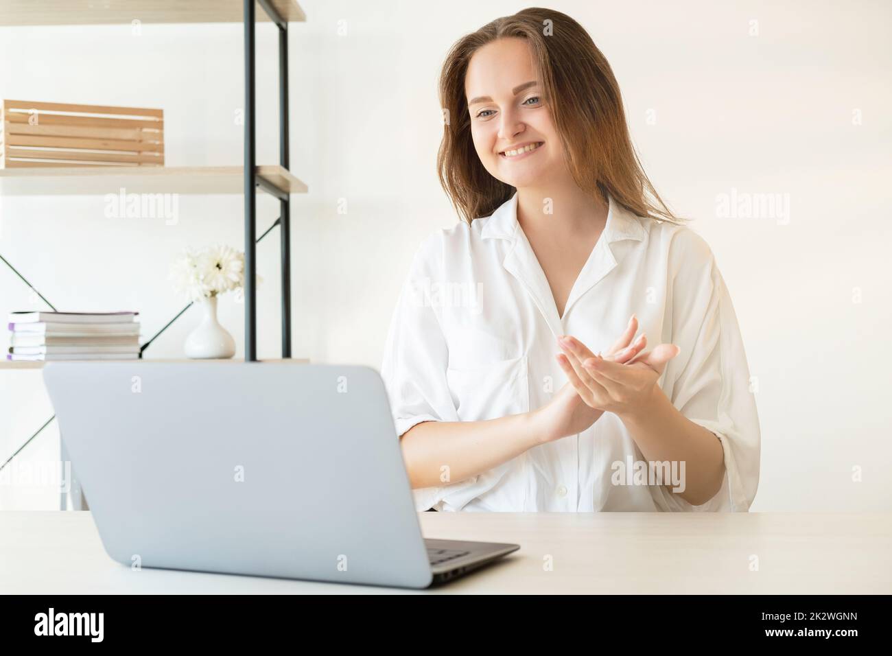 Online presentation. Successful project. Zoom chat. Online corporate meeting. Cheerful satisfied business woman supporting applauding smiling on lapto Stock Photo