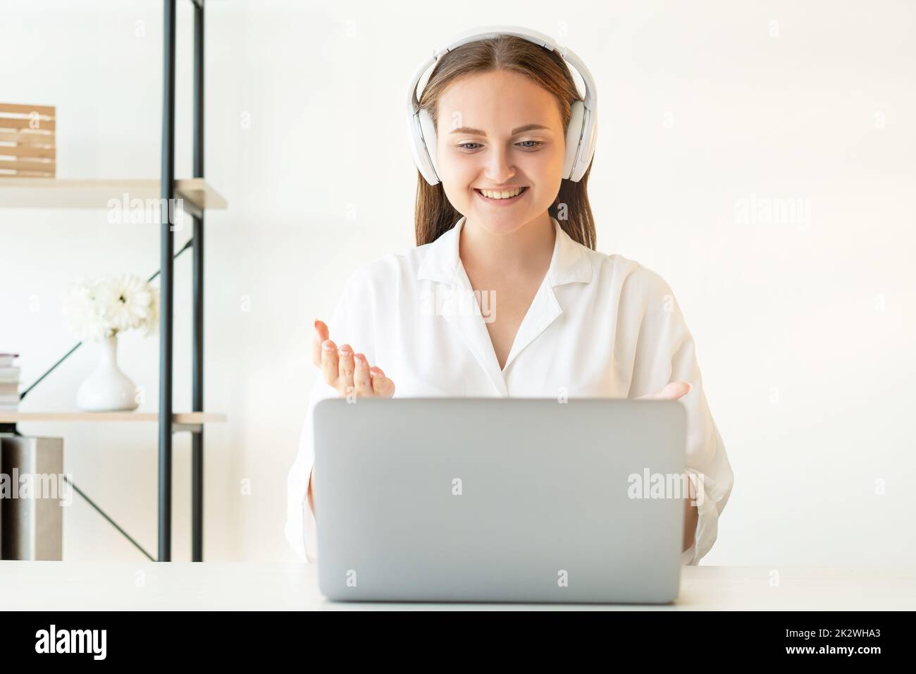 Zoom videochat. Virtual meeting. Corporate webinar. Online communication. Cheerful confident woman discussing project using white wireless headphones Stock Photo