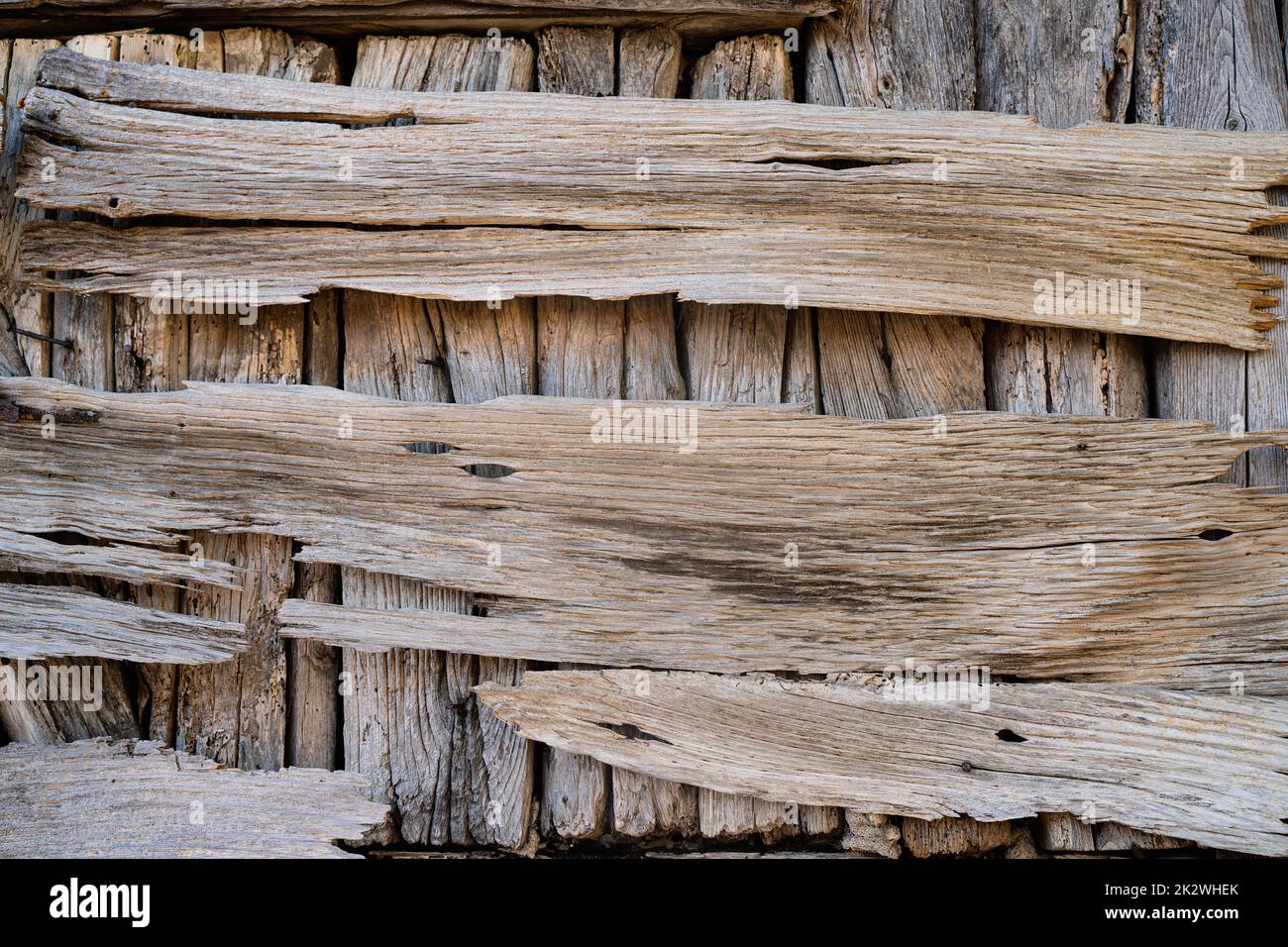front view closeup of rustic weathered brown barn wood background with knots and nail holes damaged by weather and insects Stock Photo