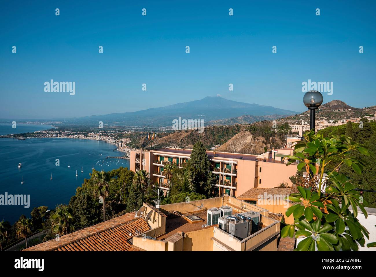Beautiful scenery of Hotel Elios and Etna Volcano by sea with sky in background Stock Photo