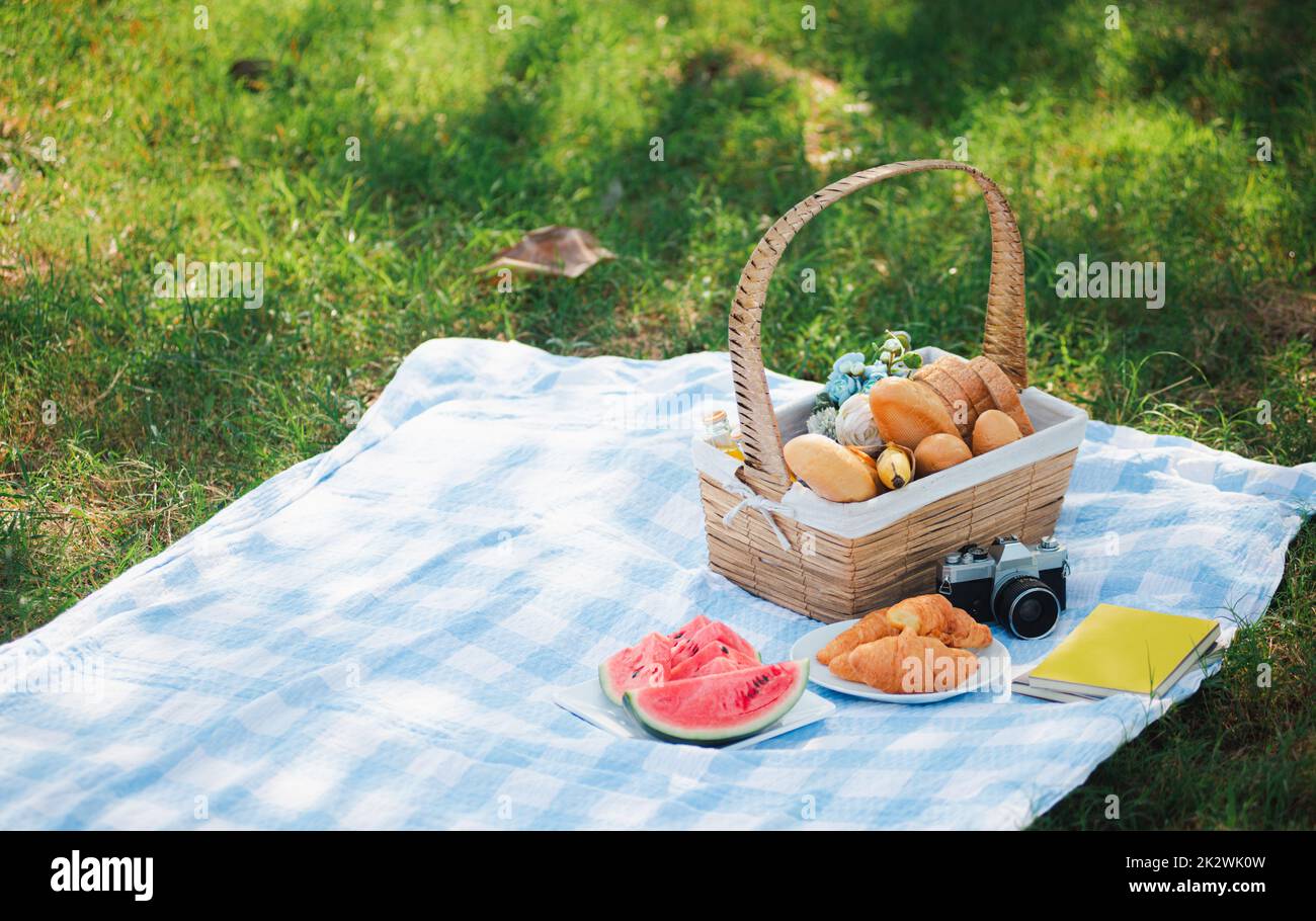 Picnic wattled basket with bread food and fruit Stock Photo - Alamy