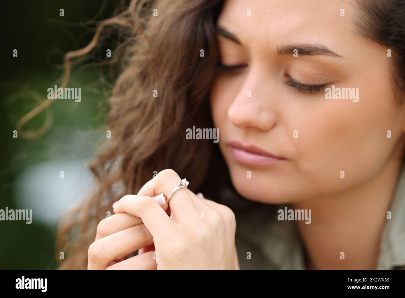 Woman looking at engagement ring in a park Stock Photo