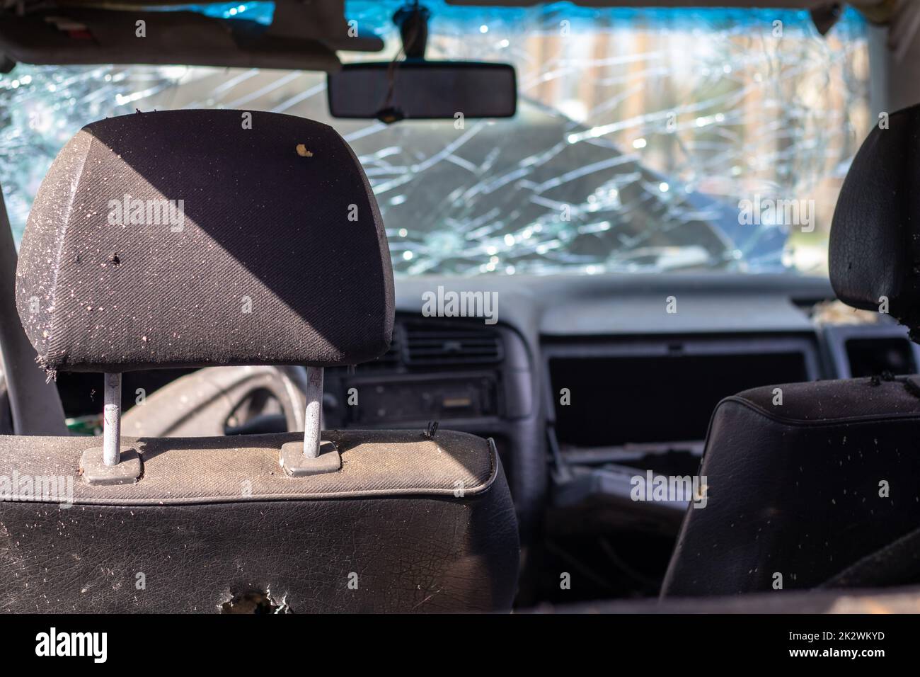 Damaged car window after an accident. Broken windshield as a result of an accident, inside view. Cabin interior details, view from the cab. Safe movement. Broken windshield. Glass crack and damage. Stock Photo