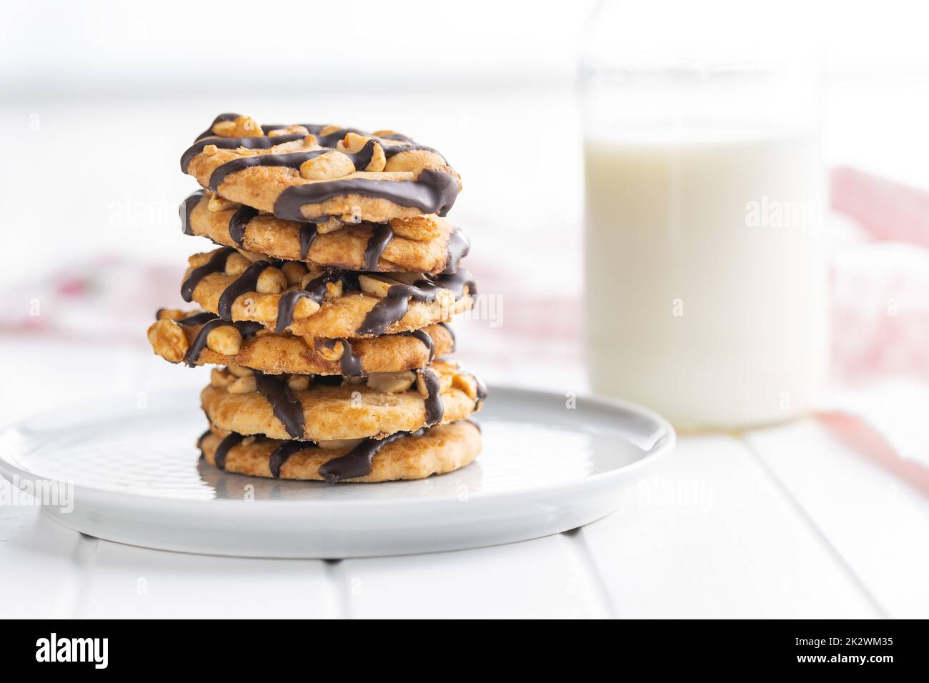Chip cookies with peanuts and chocolate strips on white table. Stock Photo