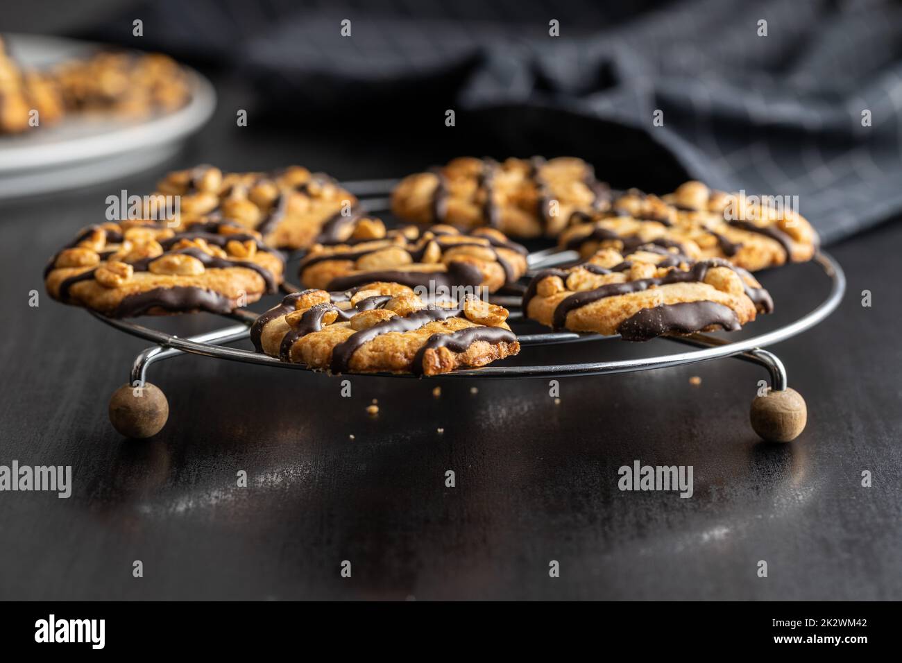 Chip cookies with peanuts and chocolate strips on black table. Stock Photo