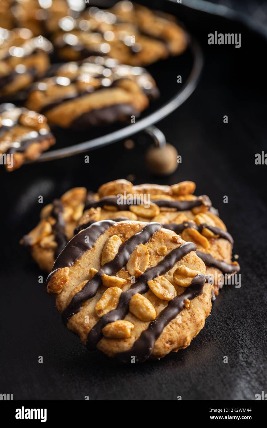 Chip cookies with peanuts and chocolate strips on black table. Stock Photo