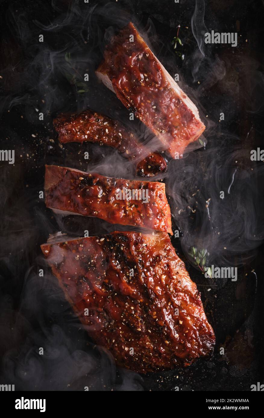 Delicious barbecued ribs seasoned with a spicy basting sauce and served on iron pan. Stock Photo