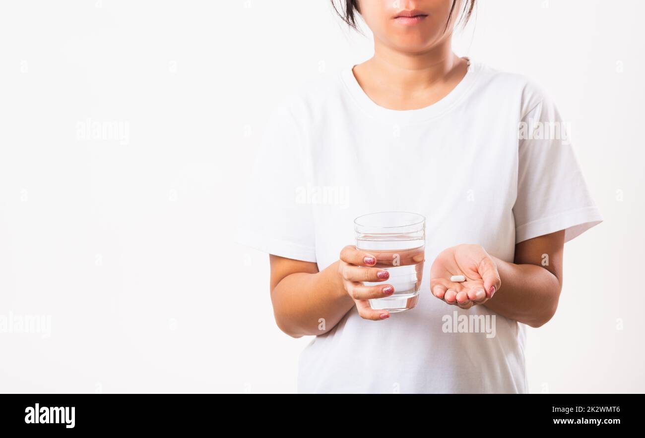 Woman hold pill drugs in hand ready take medicines with a glass of