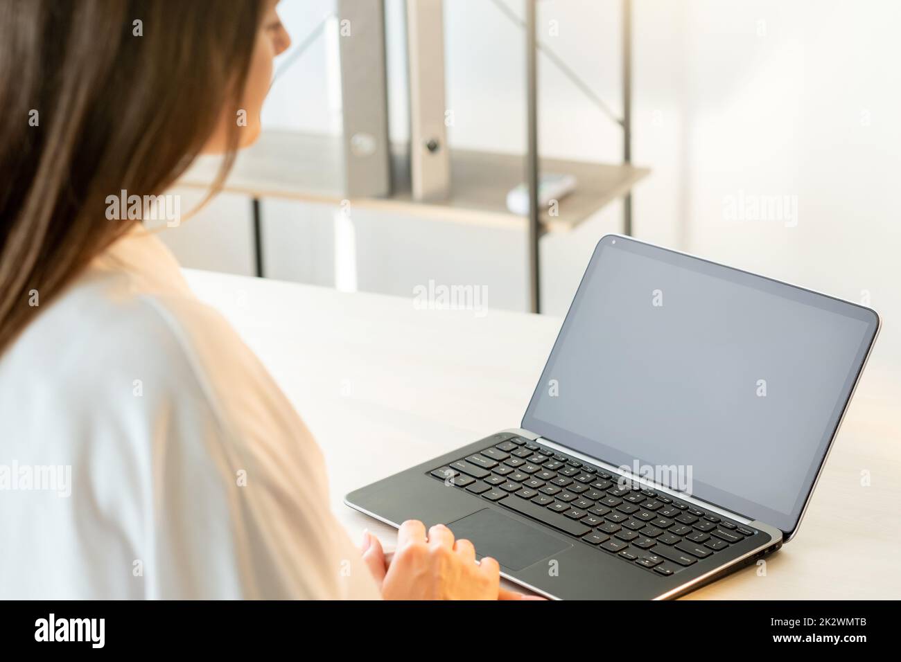Online conference. Business webinar. Zoom videochat. Distance communication. Woman using laptop with black empty screen at home office light workplace Stock Photo