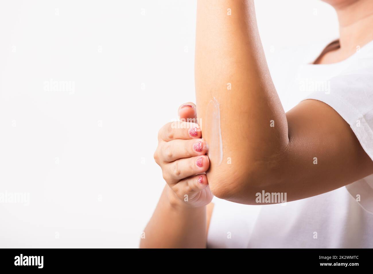 Woman applies lotion cream on her elbow Stock Photo