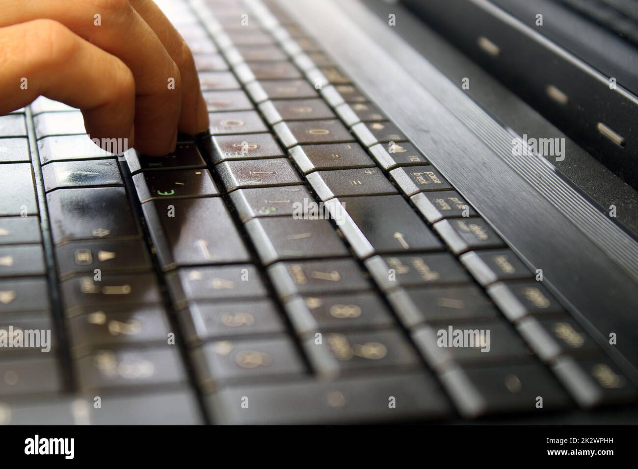 Finger of a female hand press a key on the keyboard of the laptop