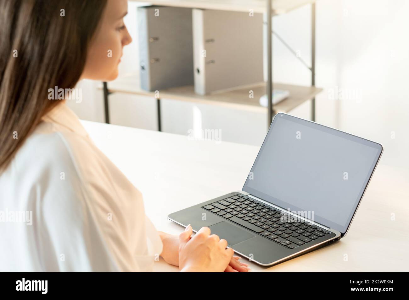 Online interview. Video conference. Virtual meeting. Remote job. Confident female leader using laptop with black empty screen working from home. Stock Photo