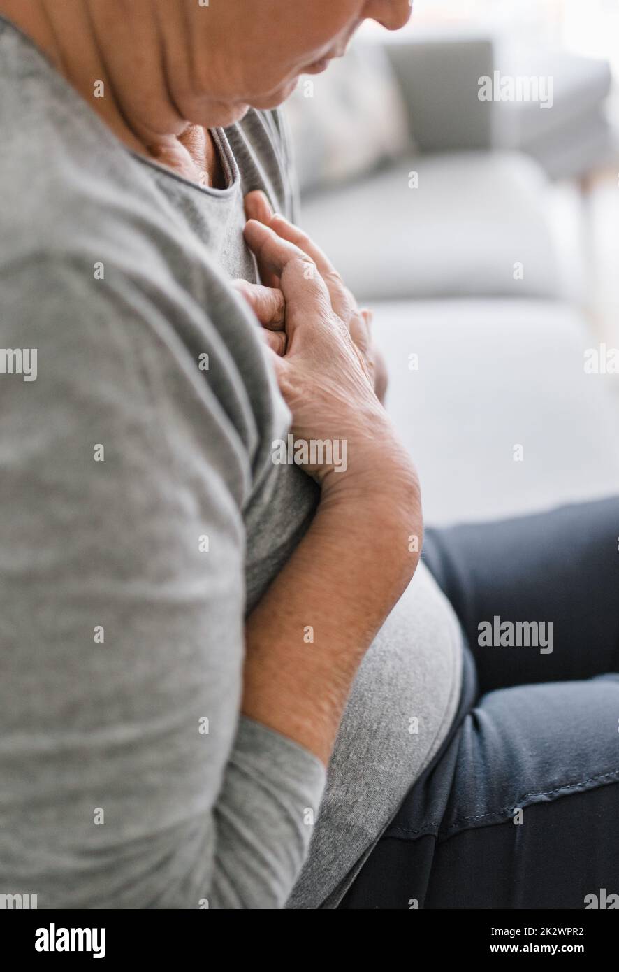 Elderly woman with heart pain holding her chest Stock Photo Alamy