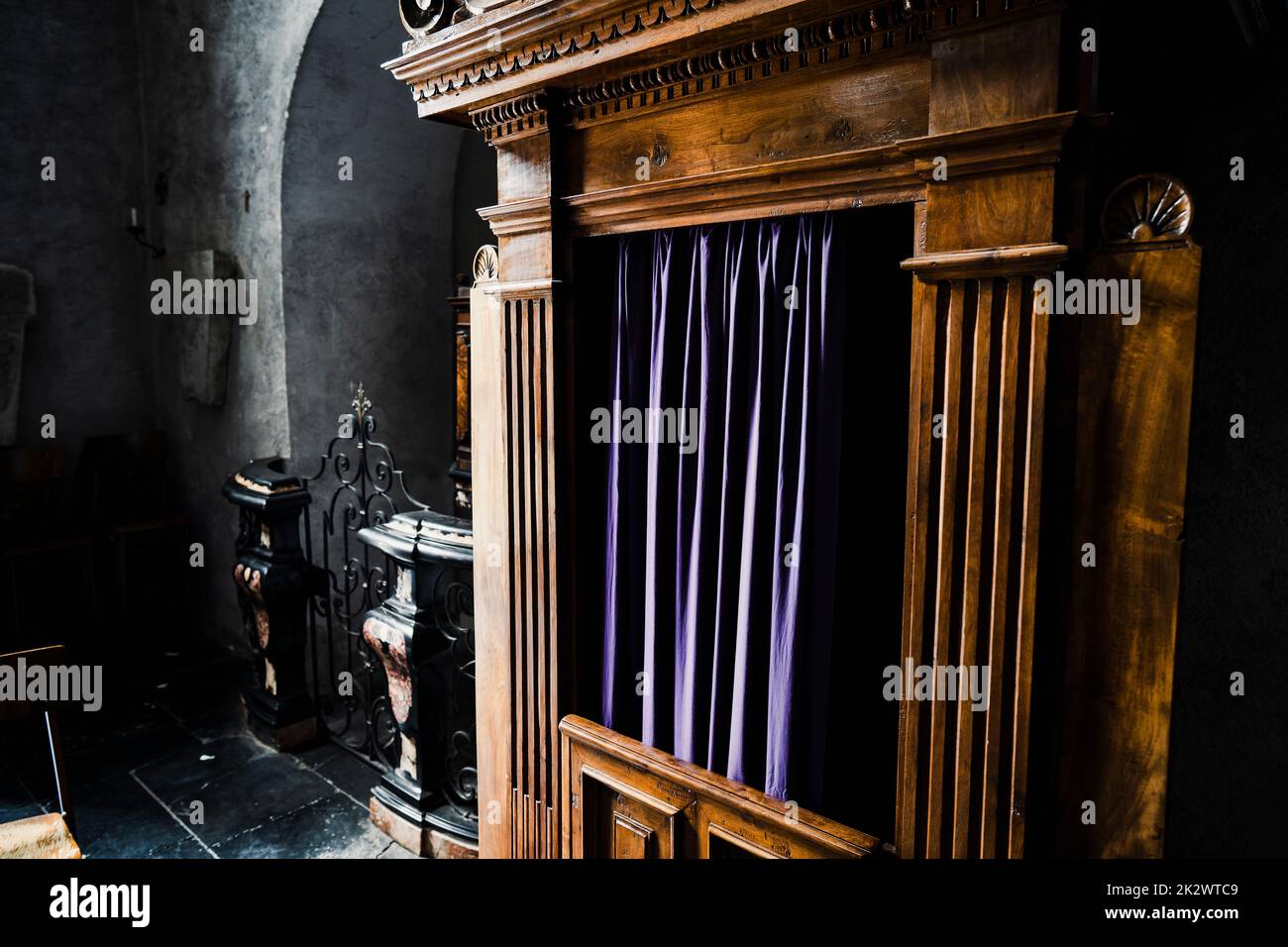 Typical old wooden confession booth at a church, with blue curtains. Stock Photo