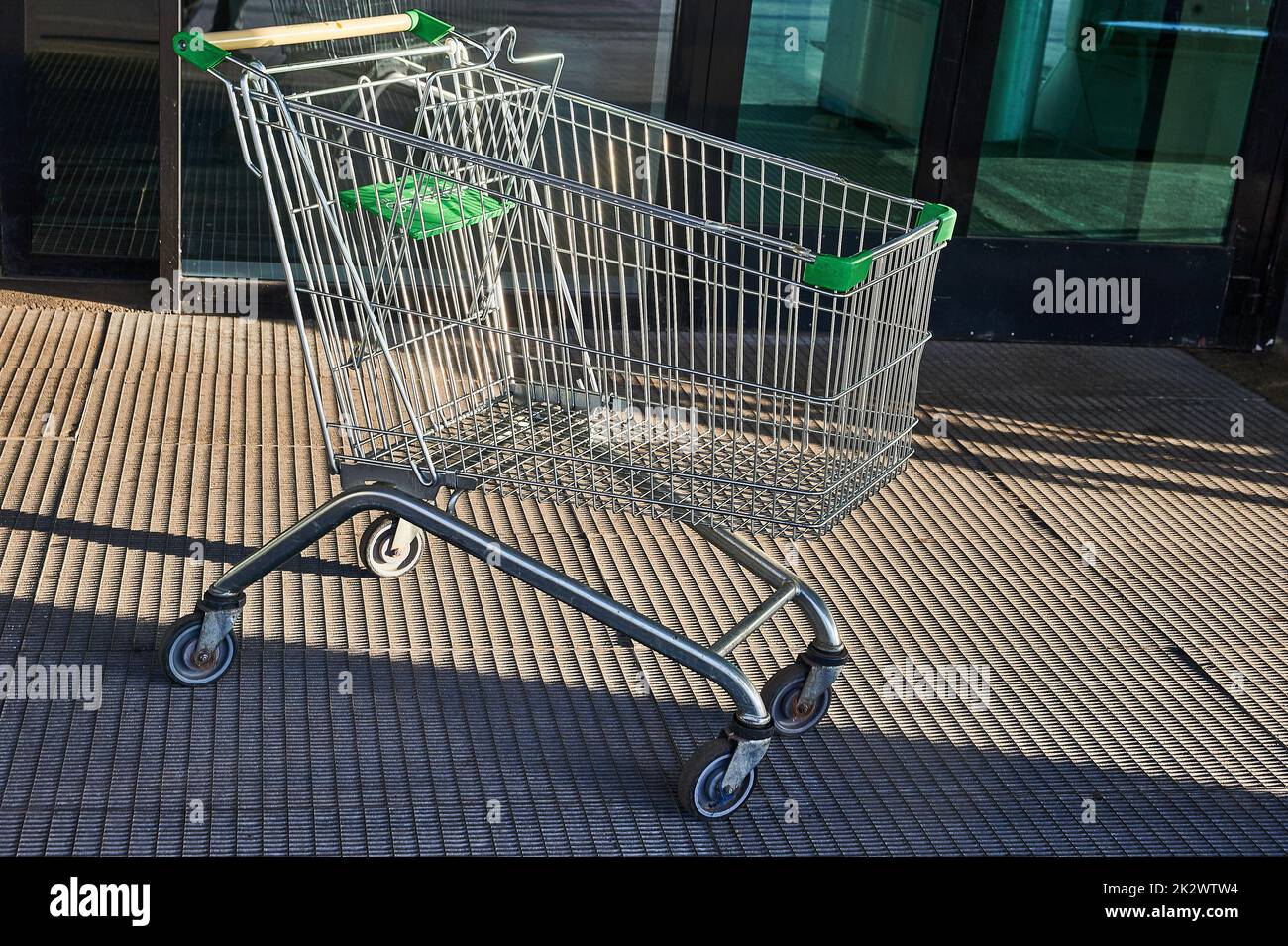 Cart for grocery products standing near the entrance to the supermarket