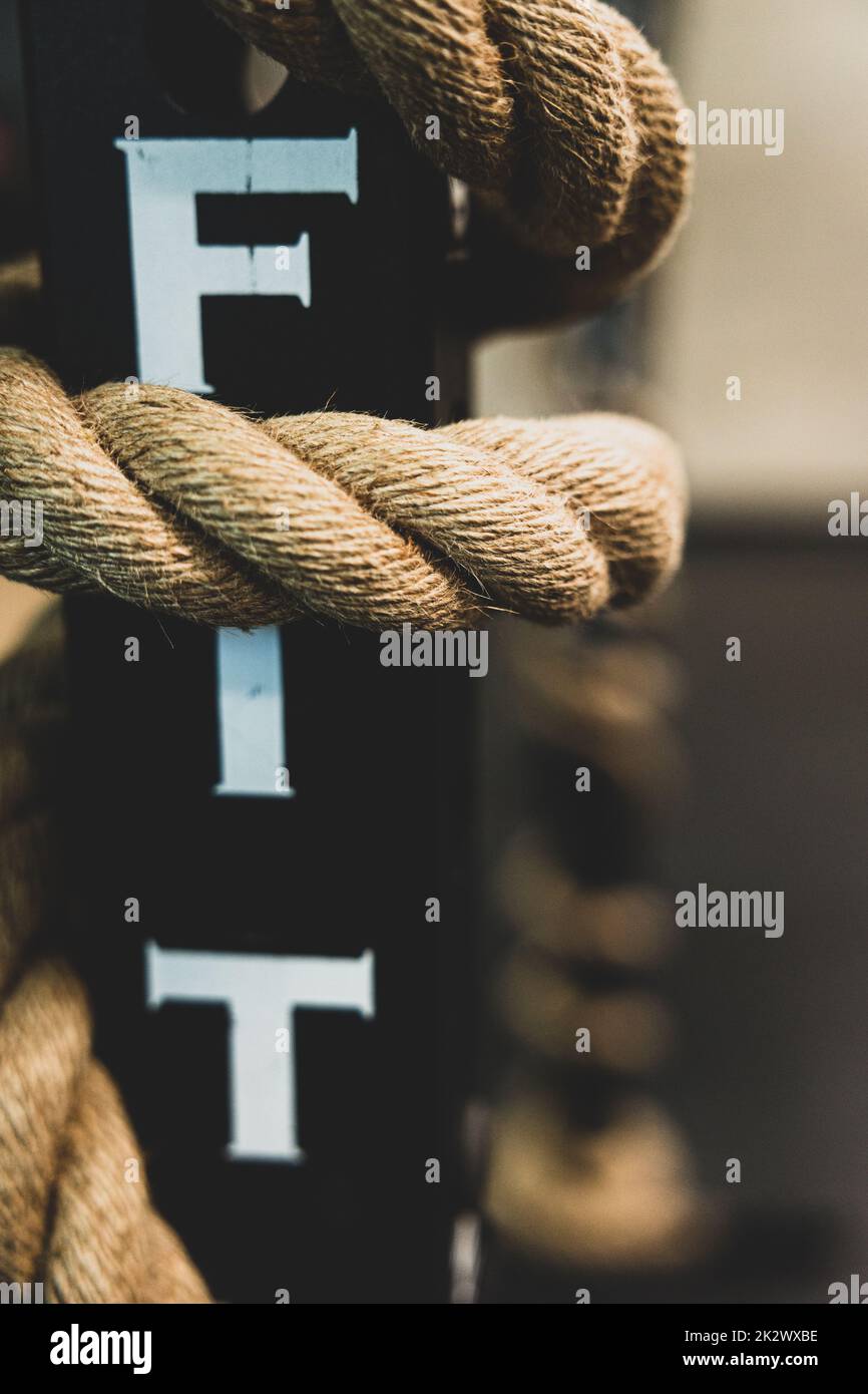 A vertical closeup shot of a thick rope for training wrapped around a ...