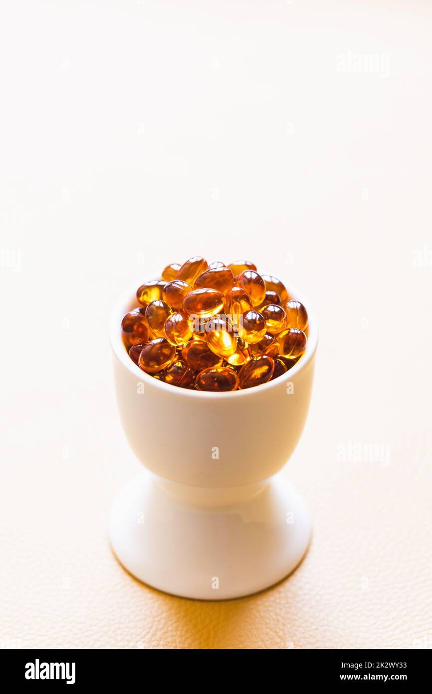 Vitamin D3 capsules. Medicine vitamins and dietary supplements. Selective focus. Close up of oil filled capsules suitable for: fish oil, omega 3, omega 6, omega 9, vitamin A, vitamin D, vitamin D3, vitamin E Stock Photo