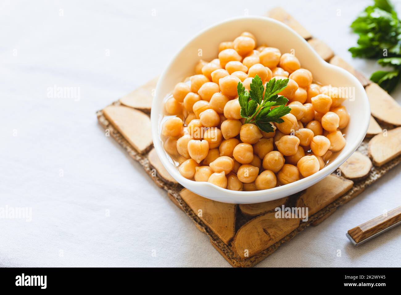 Cooked chickpeas in white bowl. Ingredient for Tasty vegetarian food. Boiled chickpeas, selective focus Stock Photo