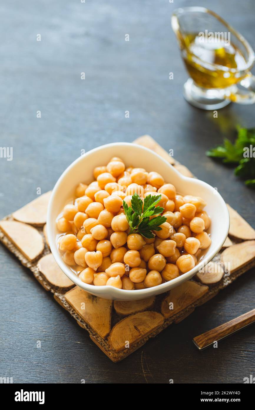 Cooked chickpeas in white bowl. Ingredient for Tasty vegetarian food. Boiled chickpeas, selective focus Stock Photo