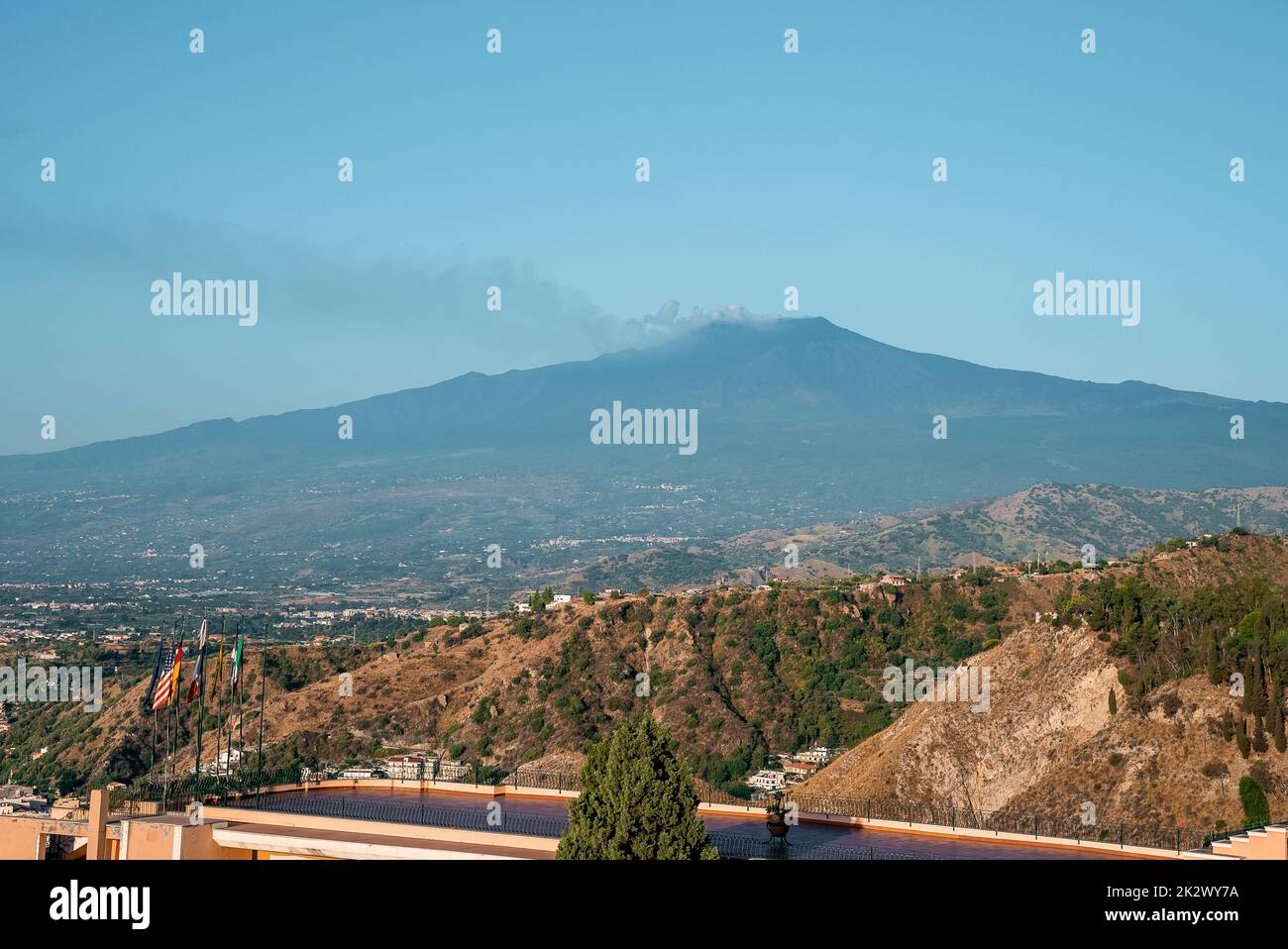 Hotel Elios overlooking scenic view of Etna Volcano with blue sky in background Stock Photo